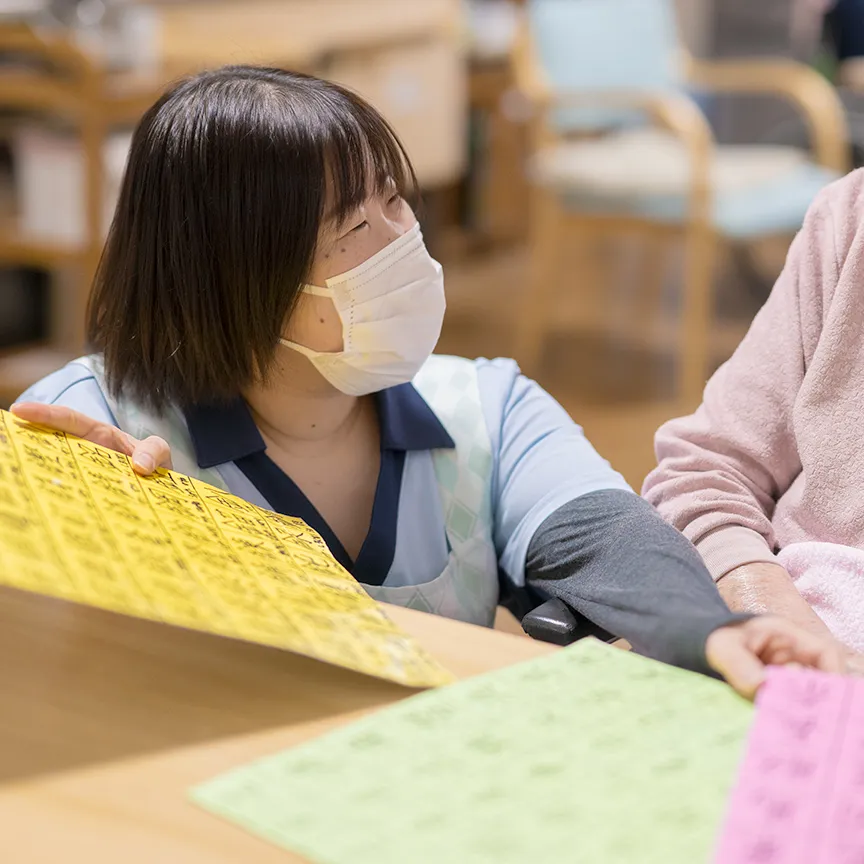 利用者と笑い合う女性スタッフの写真